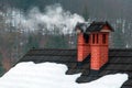 Smoke from two house chimneys in cold winter morning