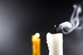 Smoke on white candle soft lens yellow candle in the dark background Royalty Free Stock Photo