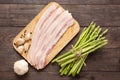 Smoked bacon with fresh asparagus on wooden background Royalty Free Stock Photo