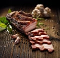 Smoked bacon on a wooden rustic table with addition of fresh aromatic herbs, top view