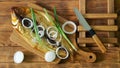 Smoked Baikal omul, green and onions on a cutting board on a wooden rustic table made of pine boards next to a knife. A rare fish