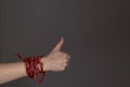 Smoked beer sausages are wrapped around the arm in the form of a bracelet and a like gesture is shown, thumbs up on a