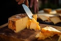 smoked cheese being sliced with knife