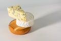 Brie and mouldy cheese are stacked on top of each other. Stack of selection of cheeses, against white background. assortment of