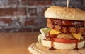 smoked chickenburger centred on wooden plate close up