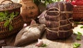 Smoked dried gammon ham and slices of sausages with bread, tomatos, herbs, garlic and basketson wooden board Royalty Free Stock Photo