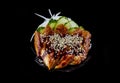 Smoked eel sashimi over black background