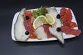 Smoked fish delicacies from the Northern seas halibut, salmon.Slices of smoked salmon and halibut on a plate with a slice of lemon Royalty Free Stock Photo