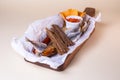 A variety of smoked fish on a wooden board with a bowl of red pepper flakes. assorted fish