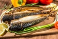 Smoked fish mackerel on a cutting Board on a background of vegetables Royalty Free Stock Photo