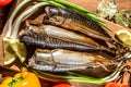 Smoked fish mackerel on a cutting Board on a background of vegetables. Royalty Free Stock Photo