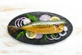 Smoked fish mackerel with onion and lemon on a black plate. Top view. Free space for your text. Royalty Free Stock Photo