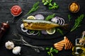 Smoked fish mackerel with onion and lemon on a black plate. Top view. Free space for your text. Royalty Free Stock Photo