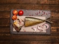 Smoked fish with onion, tomato and pepper. Food background. Smoked mackerel background. Smoked mackerel on slate board, top view. Royalty Free Stock Photo