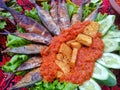 Smoked fish penyet tempeh with shrimp paste chili sauce and lettuce leaves, a typical Madurese food