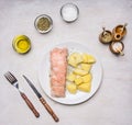 Smoked fish, with potatoes and dill on a white plate, with spices, knife and fork wooden rustic background top view close up Royalty Free Stock Photo