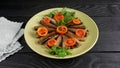 Smoked fishes of sprats without their heads with sliced tomatoes, parsley and spices in a  plate on a  table Royalty Free Stock Photo