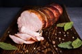 Smoked ham cut in slices on wooden rustic table