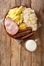 Smoked Kassler pork neck and fried sausages with Sauerkraut mashed potatoes and mustard on wooden table. Vertical top view Royalty Free Stock Photo