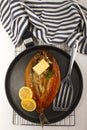 Smoked kipper with lemon, butter and parsley on a pan Royalty Free Stock Photo