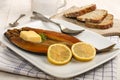 Smoked kipper with lemon, butter and parsley on a plate