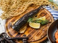 Smoked mackerel fish with lemon and rosemary on cutting board over wooden rustic background. Seafood, healthy food, top view Royalty Free Stock Photo