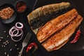 Smoked marinated mackerel fillets or fillet herring fish with spices, greens and slice of bread on plate over dark stone Royalty Free Stock Photo