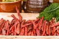 Smoked meat and greenary on picnic table at summer day.