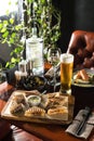 Smoked meat sandwich and glass of beer on wooden table at restaurant Royalty Free Stock Photo