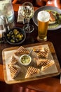 Smoked meat sandwich and glass of beer on wooden table at restaurant Royalty Free Stock Photo