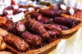 Smoked meat and sausages in wicker baskets sold on the market Royalty Free Stock Photo