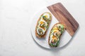 Smoked mussels and avocado toasts, white background, copy space Royalty Free Stock Photo