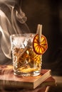 Smoked old fashioned rum cocktail with cubes of ice around on a dark background Royalty Free Stock Photo