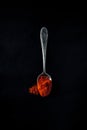 Smoked paprika, spicy, sweet on a teaspoon on a black background Royalty Free Stock Photo