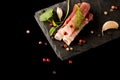 Smoked Parma Ham with Herbs, garlic and peppers on Stone Plate, composition on black background. top view, over lay