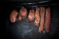 Smoked pork meat in smoker on dark background.