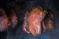 Smoked pork meat in smoker on dark background.