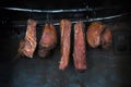 Smoked pork meat in smoker on dark background.