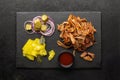 Smoked pulled pork and pickled vegetables set on a slate board, top view. Royalty Free Stock Photo