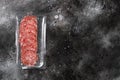 Smoked salami sausages slices in vacuum pack, on black dark stone table background, top view flat lay, with copy space for text Royalty Free Stock Photo