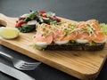 Smoked salmon bruschetta and salad on a wonden board Royalty Free Stock Photo