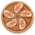 Smoked salmon bruschetta on a wooden round plate isolated