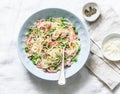 Smoked salmon, green peas, creamy sauce spaghetti - delicious lunch in the mediterranean style. On a light background Royalty Free Stock Photo
