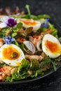 Smoked salmon and jammy soft-boiled free range egg and capers salad with edible borage and pansy flowers