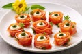 smoked salmon rosettes served with caper berries on a white plate