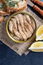 Smoked sardines in an open tin can, crispy whole grain bread, greens, lemon Royalty Free Stock Photo