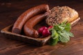 smoked sausage with bread and radish, rustic food on a wooden table Royalty Free Stock Photo