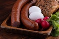 smoked sausage with bread and radish, rustic food on a wooden table Royalty Free Stock Photo