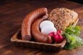 smoked sausage with bread and radish, rustic food on a wooden table Royalty Free Stock Photo