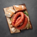 Smoked sausage with bread and spices on a wooden cutting board. Royalty Free Stock Photo